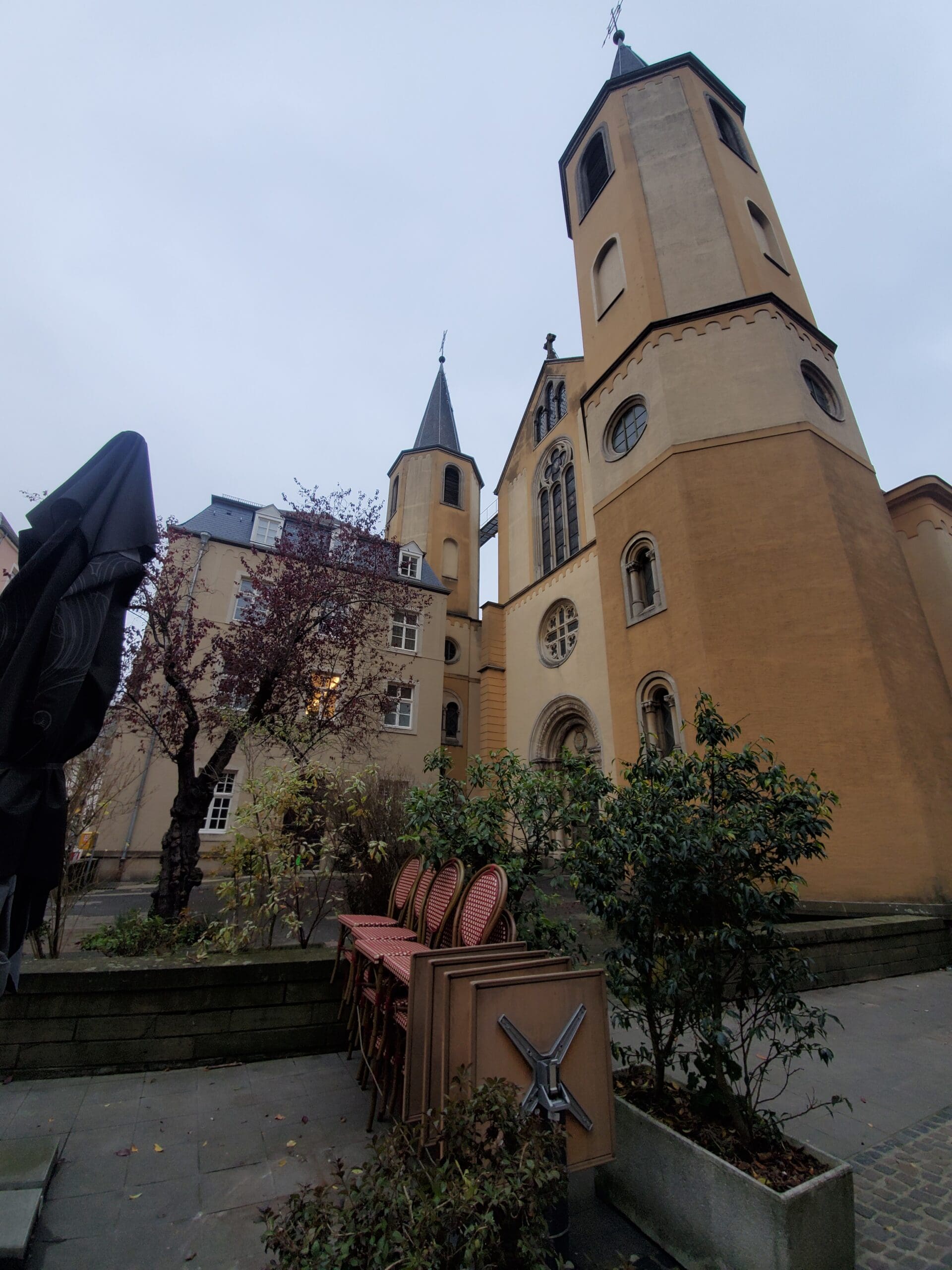 A towering Cathedral in Luxembourg with tall steeples and stained glass windows against a gray sky