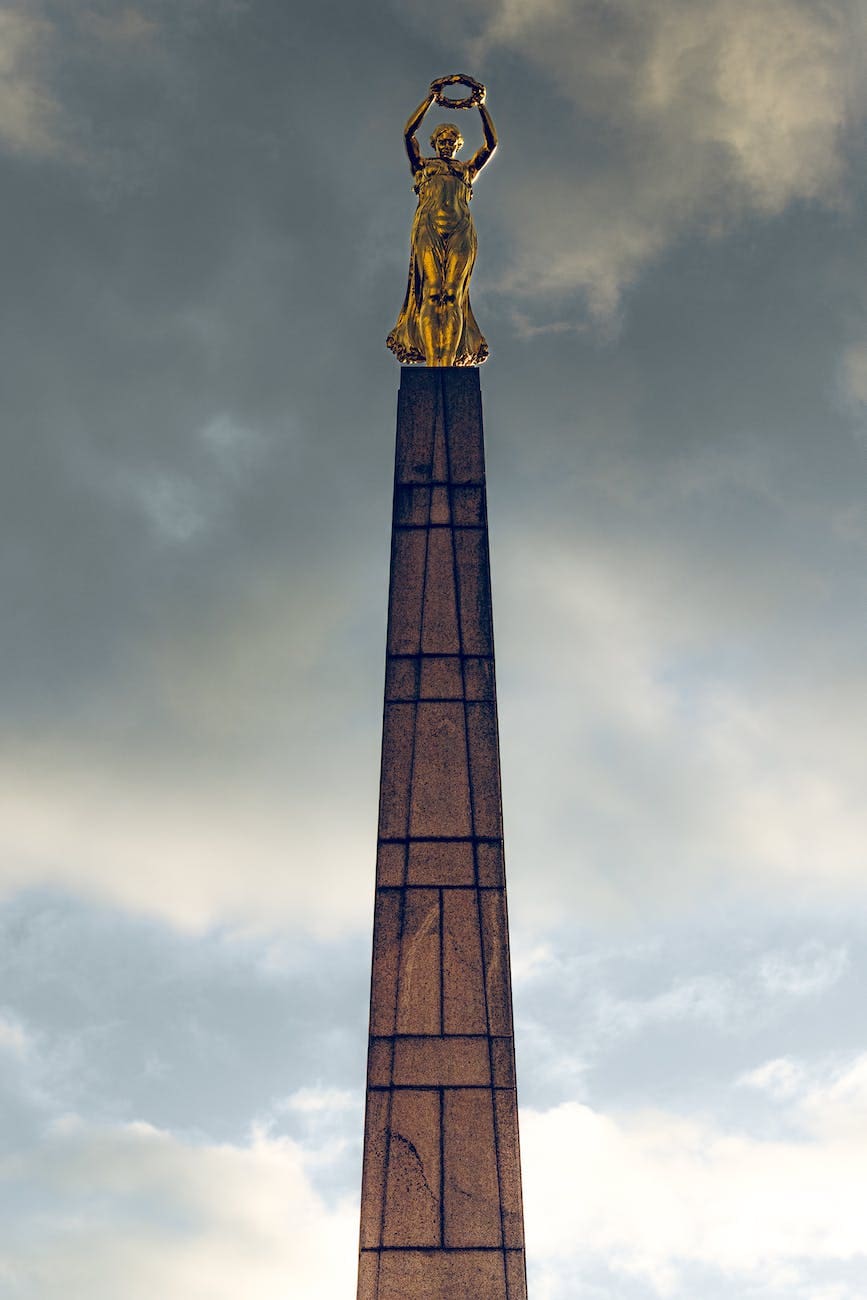 The Golden Lady Herself Gelle Fra holding a wreath on a giant pedestal 30 meters high. The sky in the background is a bit stormy.