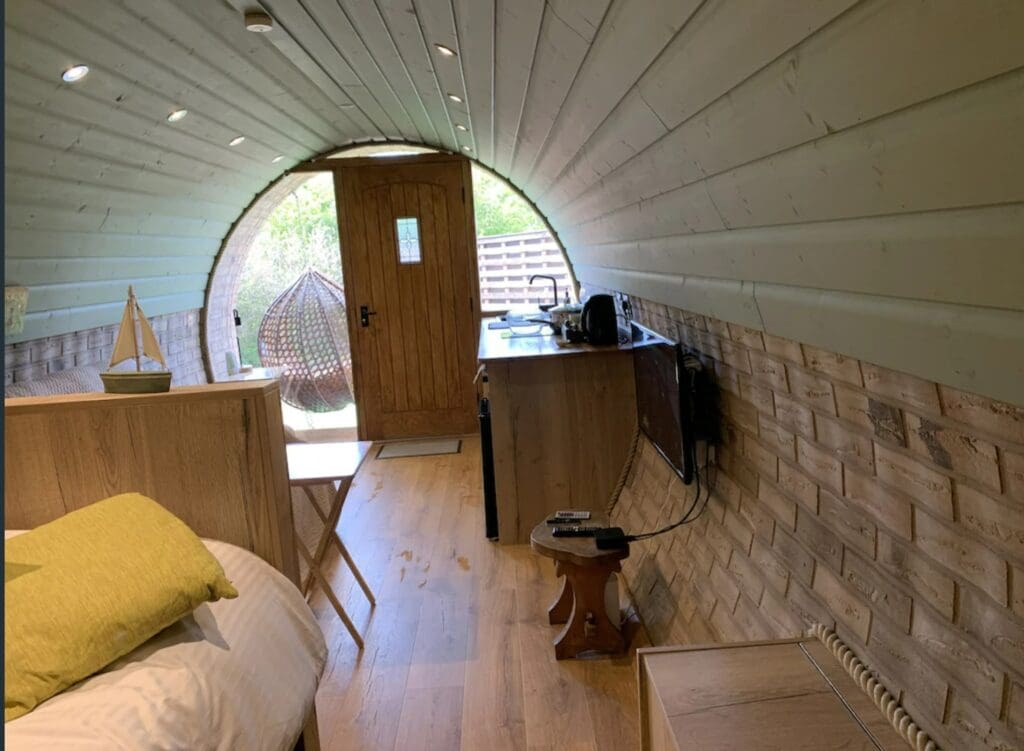 The inside of the hobbit hole complete with a tv, kitchen, and queen size bed