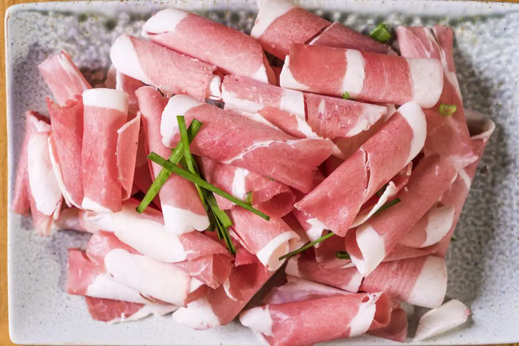 Prosciutto rolled up in a pile