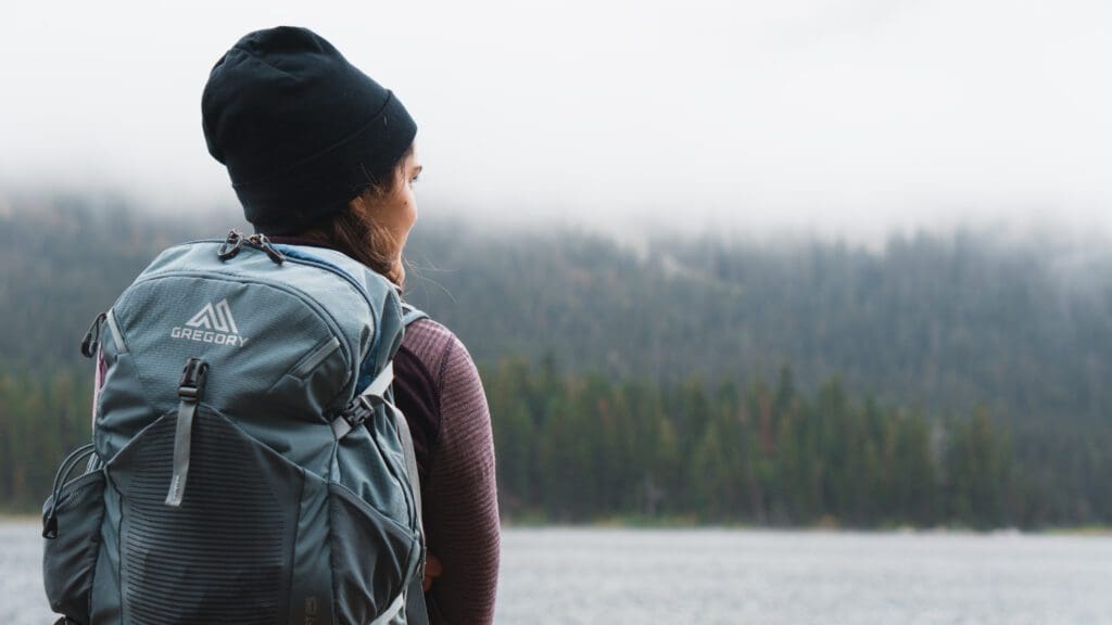 A female backpacker looking at an alpine lake